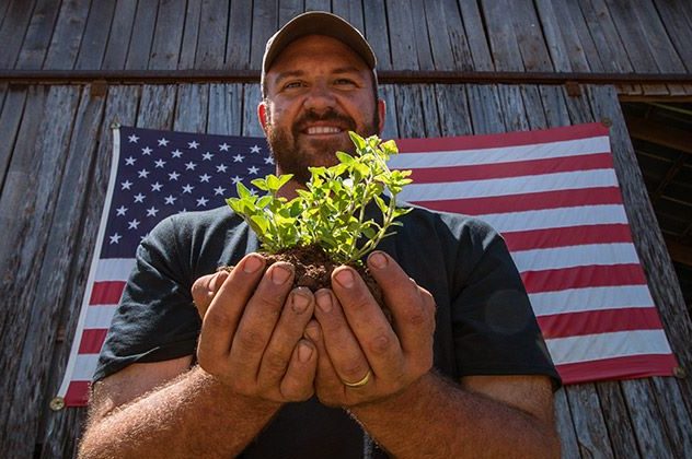Photo of a veteran carrying a plant in his hands